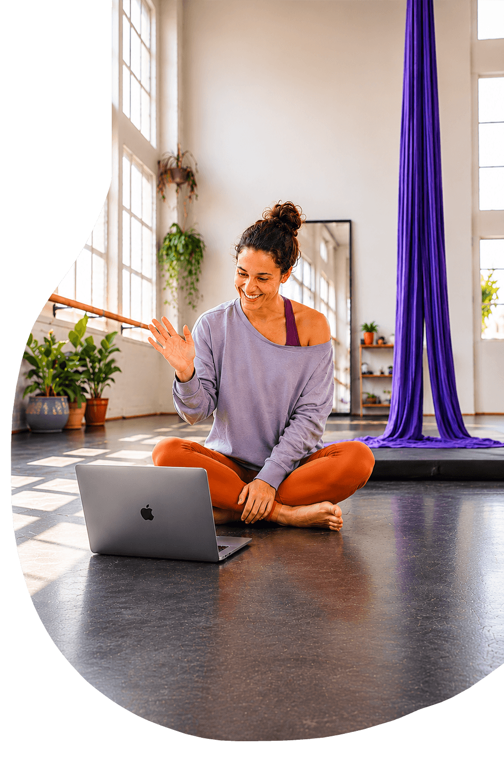 Circus artist waving during a video training session in a bright studio