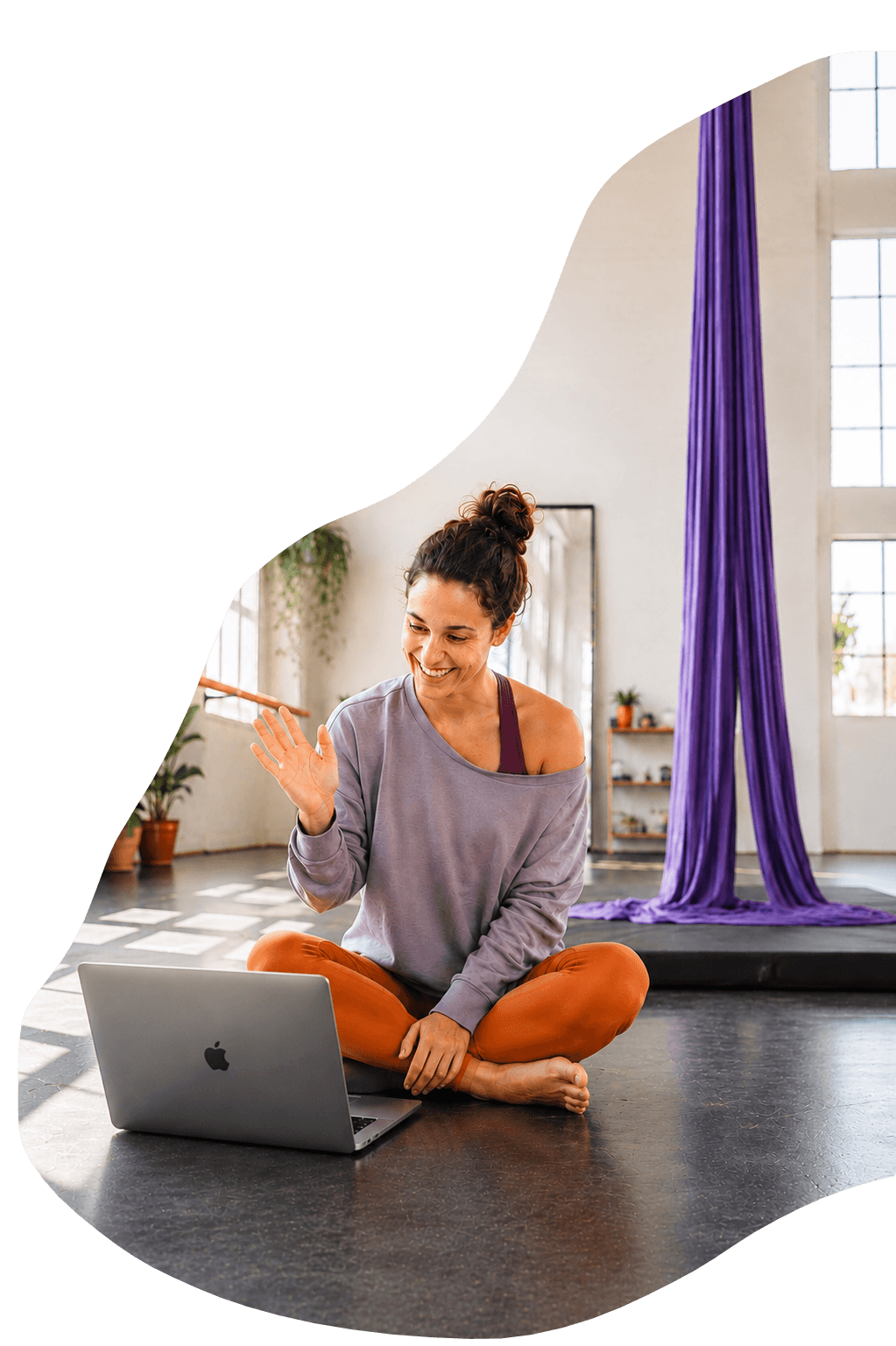 Circus artist waving during a video training session in a bright studio
